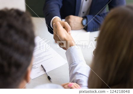 Above close up view of people shaking hands across table 124218048
