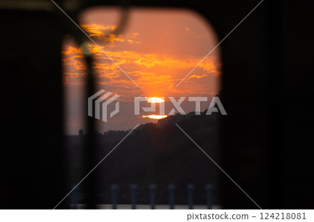 Image of watching the sunset from inside a quiet train car 124218081