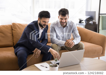 Two businessmen engaged in collaborative discussion using laptop Two businessmen engaged in collaborative discussion using laptop 124218082