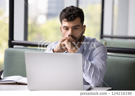 Man deeply focused on his work, staring at laptop screen Man deeply focused on his work, staring at laptop screen 124218190