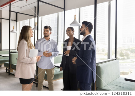 Four diverse teammates co-workers talking met in modern co-working space 124218311