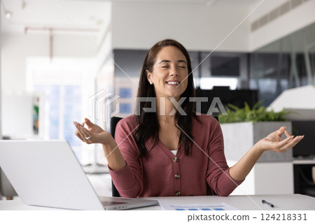 Happy peaceful Hispanic manager woman meditating in office Happy peaceful Hispanic manager woman meditating in office 124218331