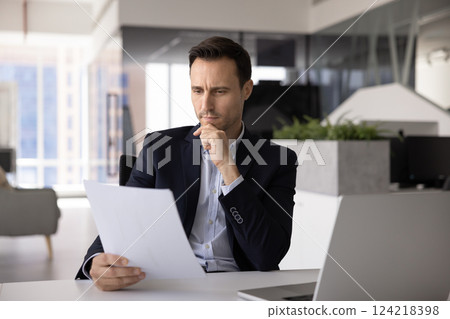 Pensive concerned Hispanic business legal expert man reading financial document Pensive concerned Hispanic business legal expert man reading financial document 124218398