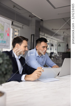 Two diverse male business colleagues working together at laptop Two diverse male business colleagues working together at laptop 124218485