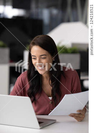 Cheerful business analyst woman working on paper document Cheerful business analyst woman working on paper document 124218521