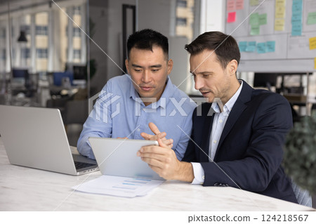 Two diverse company managers working on project together Two diverse company managers working on project together 124218567