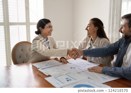 Positive Indian financial expert shaking hands with husband and wife Positive Indian financial expert shaking hands with husband and wife 124218570