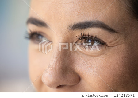 Brown eyes of young mid adult woman with smile wrinkles Brown eyes of young mid adult woman with smile wrinkles 124218571