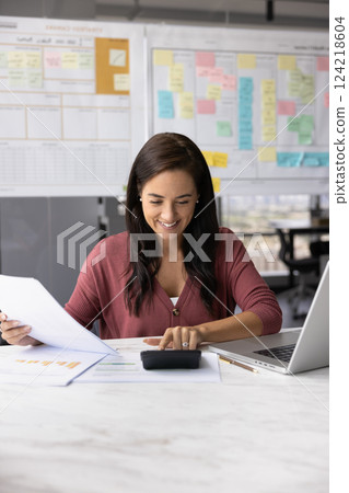 Happy Latin project manager woman counting profit 124218604