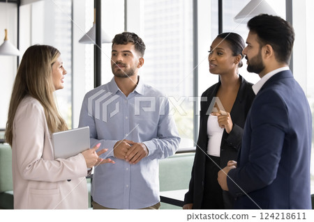 Four multiethnic workmates listening team leader explain task details 124218611