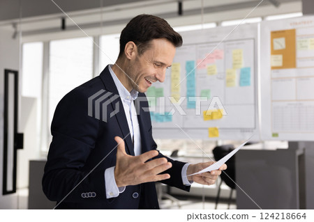 Cheerful excited Hispanic businessman making winner hand gesture 124218664
