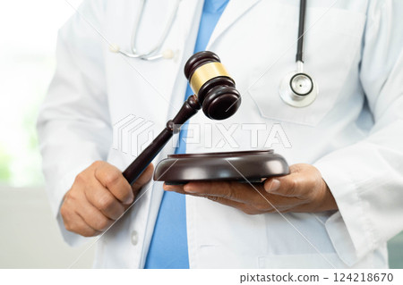 Doctor holding judge gavel, medical law and crime justice. Doctor holding judge gavel, medical law and crime justice. 124218670