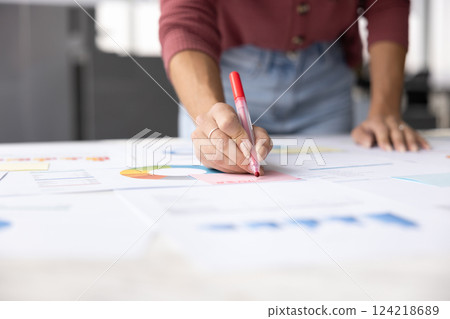 Cropped shot of project manager writing notes on paper reports 124218689