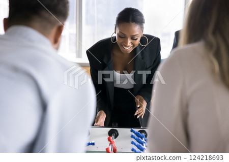 Young African office employee businesswoman engaged in playing foosball Young African office employee businesswoman engaged in playing foosball 124218693
