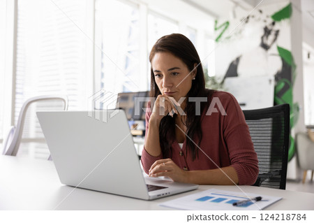 Thoughtful serious business project manager working at laptop 124218784