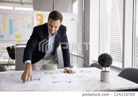 Positive businessman reviewing marketing research results for startup project 124218789