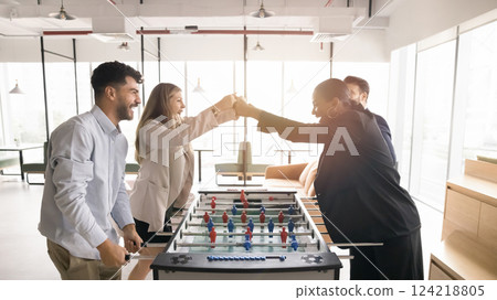 Four colleagues engaging in foosball game in co-working area Four colleagues engaging in foosball game in co-working area 124218805