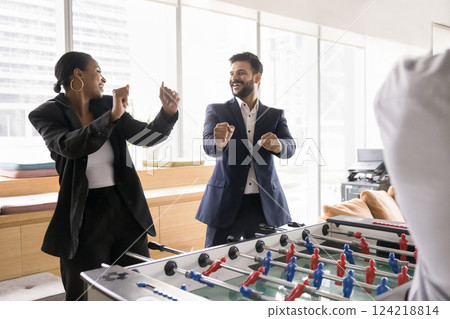 Colleagues winning foosball game, dancing, joyfully celebrating moment of victory 124218814