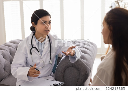 Candid portrait on young Indian doctor woman visiting patient 124218865