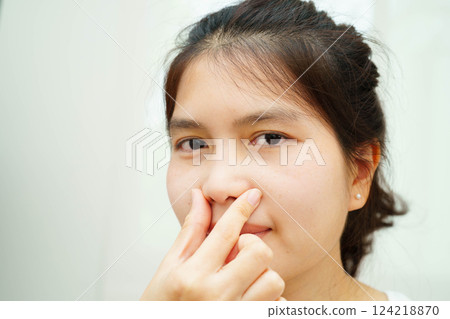 Asian woman receiving plastic surgery shape of nose performed on face. Asian woman receiving plastic surgery shape of nose performed on face. 124218870