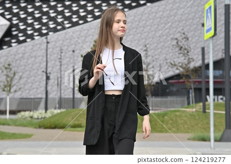 Woman crossing a street on a pedestrian crosswalk in an urban area. 124219277