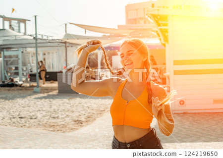 Woman Braids Hair Beach Summer Vacation Outdoors: Happy Girl Styling Pigtails near Beach Cabanas 124219650