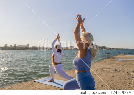 Yoga, Beach, Women practicing yoga poses on a beach at sunset. Yoga, Beach, Women practicing yoga poses on a beach at sunset. 124219759