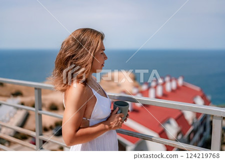 Woman Coffee Sea: Woman enjoys coffee on balcony, overlooking ocean, possibly relaxing vacation time. Woman Coffee Sea: Woman enjoys coffee on balcony, overlooking ocean, possibly relaxing vacation time. 124219768
