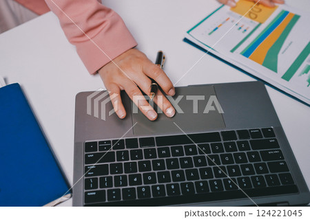 Cropped image of professional businesswoman working at her office via laptop, young female manager using portable computer device while sitting at modern loft, flare light, work process concept 124221045