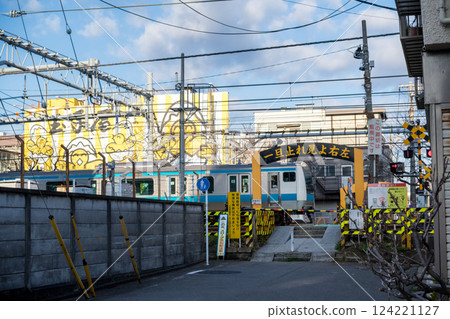 [Keihin Tohoku Line] A local train passing through a railroad crossing early in the morning 124221127