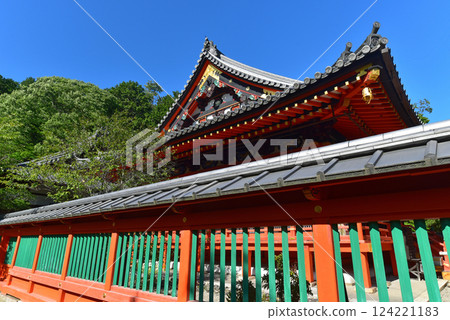 The vermilion-painted Bishamon-do temple gate stands out against the blue sky 124221183