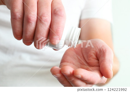 Plastic container for pills in hand on white background, close up Plastic container for pills in hand on white background, close up 124221992