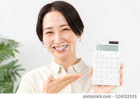 Woman with a calculator smiling Woman with a calculator smiling 124222533