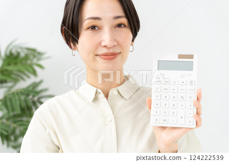 Woman with a calculator smiling Woman with a calculator smiling 124222539