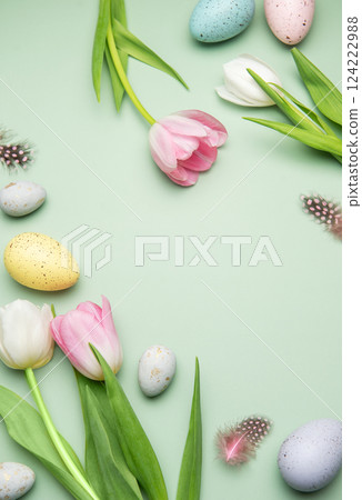 Easter eggs and tulips creating a frame on pastel green background 124222988