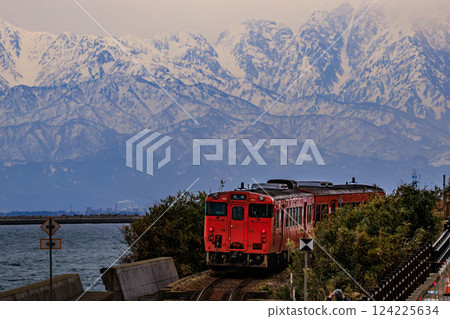 冰見線列車以美麗的立山山脈為背景,呈現壯麗的景色 冰見線列車以美麗的立山山脈為背景,呈現壯麗的景色 124225634
