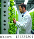 professional holding a tablet against the background of an industrial complex, showcasing digital connectivity. 124225804