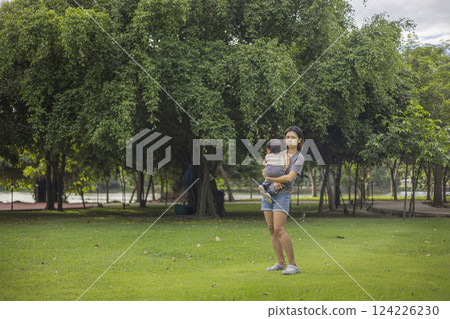Mother Carries Her Child For A Walk In The Park 124226230