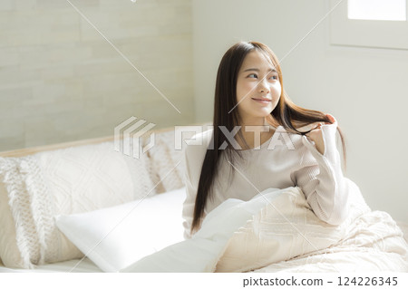 A woman experiencing the effects of hair care in bed 124226345