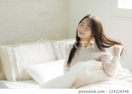 A woman experiencing the effects of hair care in bed 124226346