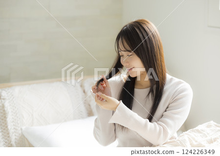 一位女士在床上體驗護髮的效果 124226349