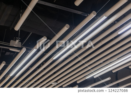 Suspended tube ceiling decoration with integrated linear lighting for diffused illumination, ideal for public space 124227086