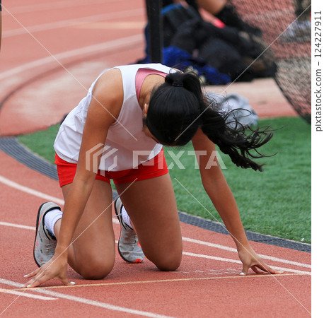 Female Runner in the Start Position on a track 124227911