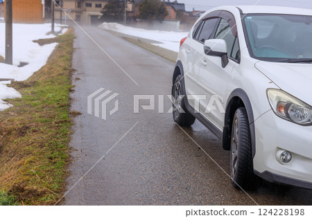 A four-wheel drive vehicle with all-season tires and a snowy landscape 124228198