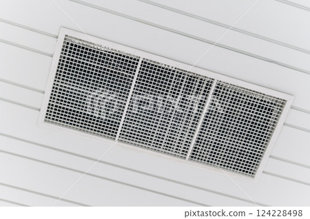 Ceiling mounted cassette type air conditioner and modern lamp light on a white ceiling. duct air conditioner for office or home Ceiling mounted cassette type air conditioner and modern lamp light on a white ceiling. duct air conditioner for office or home 124228498