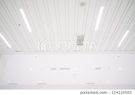 Ceiling mounted cassette type air conditioner and modern lamp light on a white ceiling. duct air conditioner for office or home 124228503