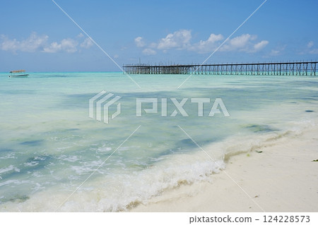 Pier and fishing boat on jambiani beach at Indian Ocean in African Zanzibar island in Tanzania Pier and fishing boat on jambiani beach at Indian Ocean in African Zanzibar island in Tanzania 124228573