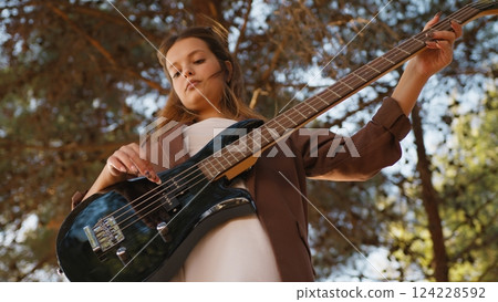 Italian Girl Plays Bass In The Mountains Among The Trees 124228592