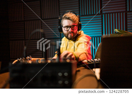 Sound engineer working at mixing panel in the boutique recording studio. Sound engineer working at mixing panel in the boutique recording studio. 124228705