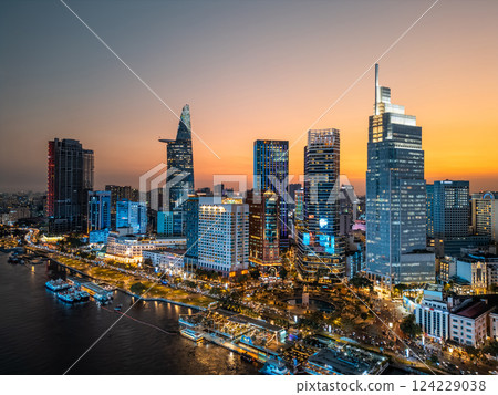 night view of illuminated Ho Chi Minh city skyline and Saigon river, neon street lights of financial downtown district with tall skyscraper towers, Vietnam aerial drone view 124229038